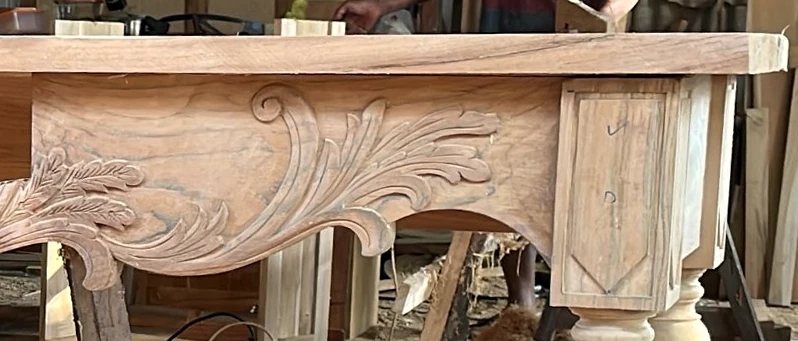 A hand-carved acanthus panel on a console in the workshop